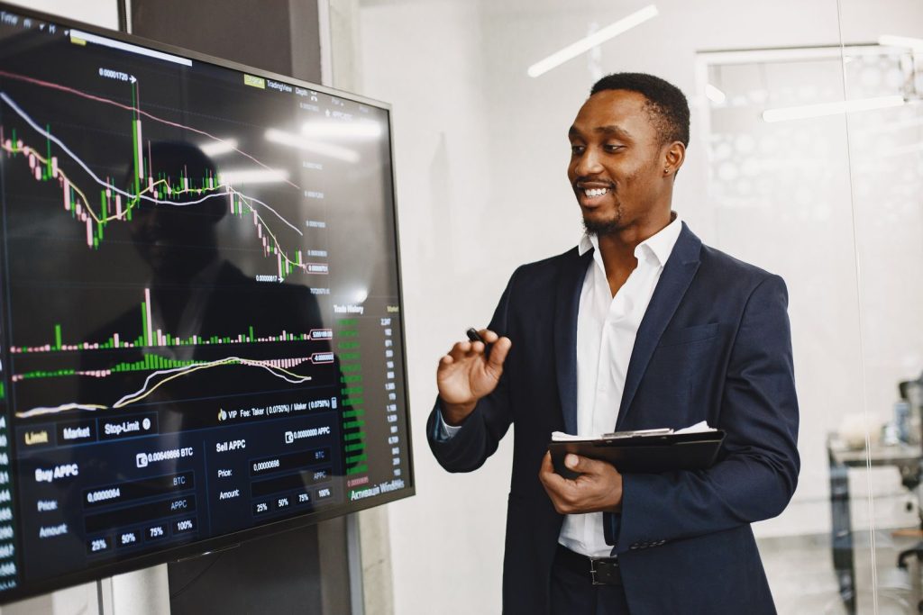 Professional man presenting financial data on a digital screen in modern office.